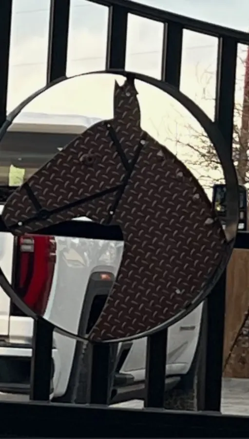 Custom horse-head medallion cut from diamond plate steel for an iron gate